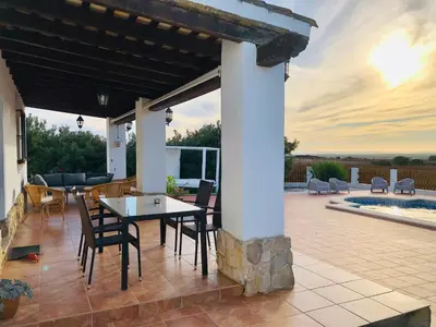 a patio with a table and chairs and a pool at Casa Con Encanto Solo Familia in Conil de la Frontera