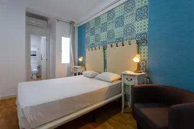 a bedroom with a white bed and a blue wall at Apartamentos El BALNEARIO by Cadiz4Rentals in Cádiz