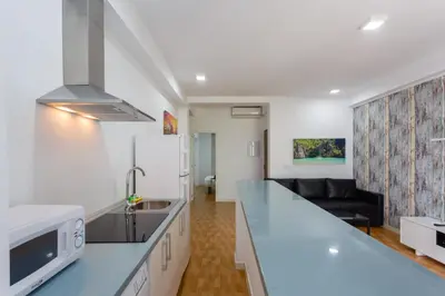 a kitchen with a counter top and a living room at Apartamentos El BALNEARIO by Cadiz4Rentals in Cádiz