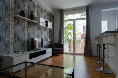a living room with a glass table and a television at Apartamentos El BALNEARIO by Cadiz4Rentals in Cádiz