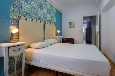 a bedroom with a white bed and a blue wall at Apartamentos El BALNEARIO by Cadiz4Rentals in Cádiz