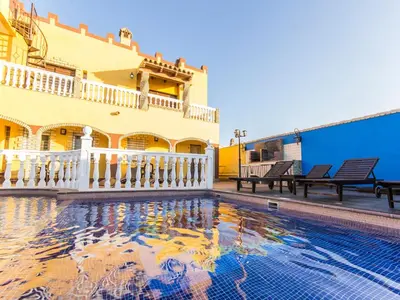 a house with a swimming pool in front of a building at Oasis de Cádiz in Conil de la Frontera