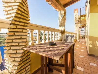 a wooden table on the balcony of a house at Oasis de Cádiz in Conil de la Frontera