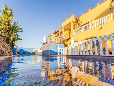 a swimming pool in front of a building at Oasis de Cádiz in Conil de la Frontera