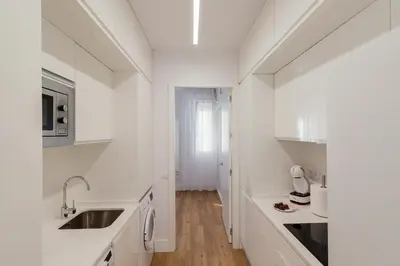 a white kitchen with white cabinets and a sink at Apartamento Barrocal in Cádiz