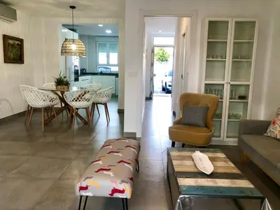 a living room with a couch and a table at GATU PREMIUM Conil Sunset house con piscina, 3 dormit, 3 baños, jardín privado , wifi y parking, preferente mayores de 21 años y familias in Conil de la Frontera