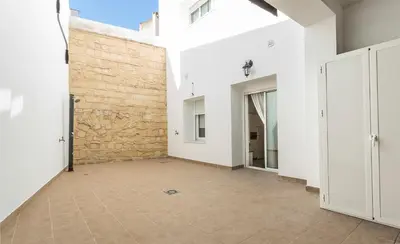 an empty hallway with white walls and a brick wall at Los Corceles Casa Palacio in Jerez de la Frontera