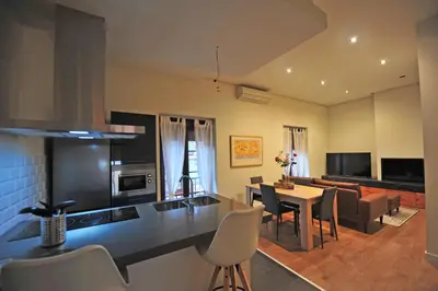 a kitchen and living room with a table and chairs at Los Corceles Casa Palacio in Jerez de la Frontera