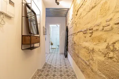 a hallway with a stone wall and a tile floor at Allo Apartments San Francisco Centro Loft in Jerez de la Frontera