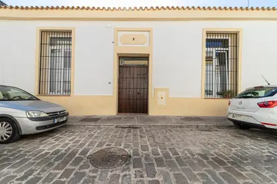two cars parked in front of a building with a door at Allo Apartments San Francisco Centro Loft in Jerez de la Frontera