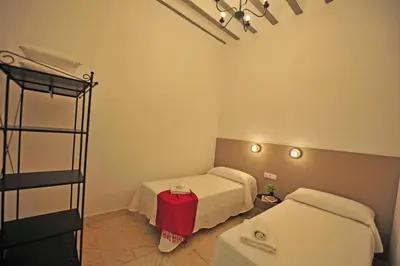 a room with two beds in a room at Apartamentos Casa Rosaleda in Jerez de la Frontera