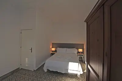 a bedroom with a white bed and two lamps at Apartamentos Casa Rosaleda in Jerez de la Frontera