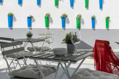 a table and chairs with wine glasses and potted plants at Apartamentos Casa Rosaleda in Jerez de la Frontera
