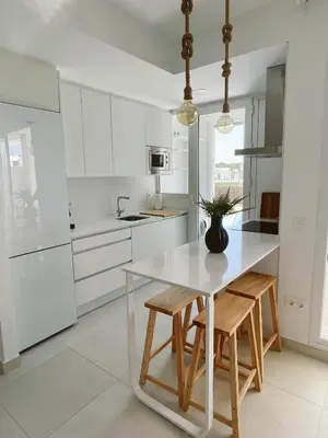 a white kitchen with a white table and chairs at Costa Ballena Terrace Beach House in Costa Ballena