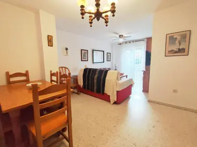 a bedroom with a bed and a table and a dining room at Beach Apartment La Costilla - Free Parking in Rota