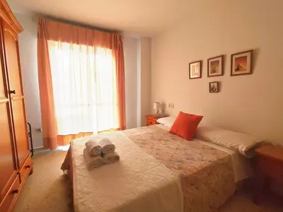 a bedroom with a bed with two towels on it at Beach Apartment La Costilla - Free Parking in Rota