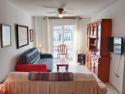 a bedroom with a bed and a chair and a couch at Beach Apartment La Costilla - Free Parking in Rota