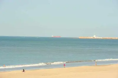 a group of people on a beach near the ocean at Preciado apartamento con vistas frontales al mar in Cádiz