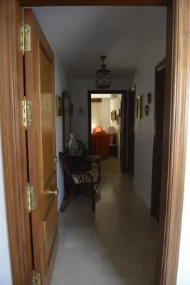 a hallway with a door and a chair in a room at CASA PALACIO LAS PALOMAS in Sanlúcar de Barrameda