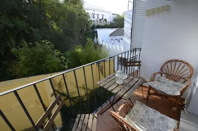 a balcony with two chairs and a table at CASA PALACIO LAS PALOMAS in Sanlúcar de Barrameda