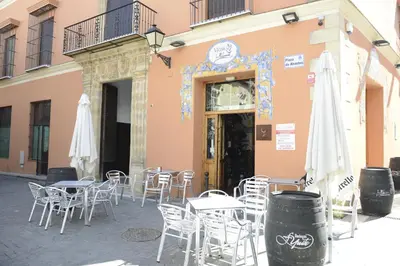 a group of tables and chairs in front of a building at CASA PALACIO LAS PALOMAS in Sanlúcar de Barrameda
