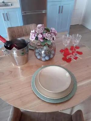 a wooden table with a plate and flowers on it at Estudio jacuzzi Luz de Jerez in Jerez de la Frontera