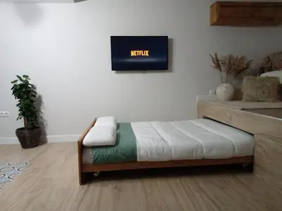 a bedroom with a bed and a tv on the wall at Estudio jacuzzi Luz de Jerez in Jerez de la Frontera