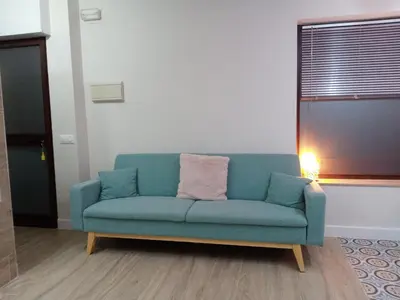 a blue couch in a living room with a lamp at Estudio jacuzzi Luz de Jerez in Jerez de la Frontera