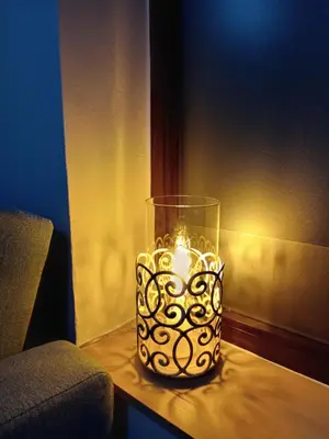 a candle in a glass vase on a table at Estudio jacuzzi Luz de Jerez in Jerez de la Frontera