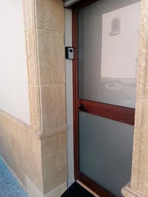 a glass door in a building with a stone pillar at Estudio jacuzzi Luz de Jerez in Jerez de la Frontera