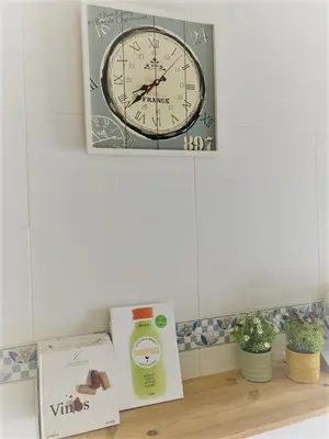 a clock on a wall above a shelf with a box at El Envero Apartamento in Jerez de la Frontera