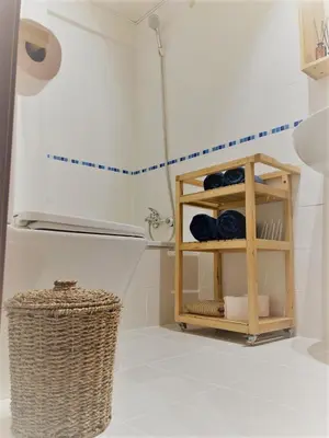 a bathroom with a shower and a shelf with towels at El Envero Apartamento in Jerez de la Frontera