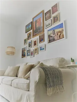 a white couch in a living room with pictures on the wall at El Envero Apartamento in Jerez de la Frontera
