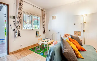 a living room with a bed and a table at Lovely Home In Chiclana De La Fronter in Novo Sancti Petri