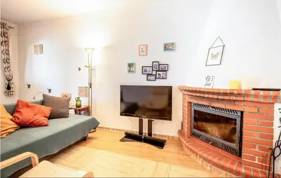 a living room with a couch and a fireplace at Lovely Home In Chiclana De La Fronter in Novo Sancti Petri