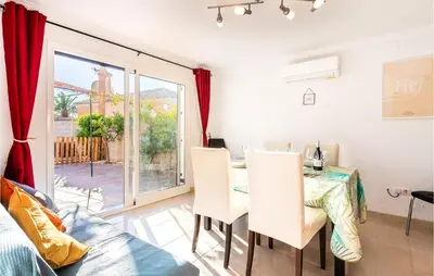 a dining room with a table and chairs and a window at Lovely Home In Chiclana De La Fronter in Novo Sancti Petri