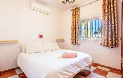 a bedroom with a white bed and a window at Lovely Home In Chiclana De La Fronter in Novo Sancti Petri