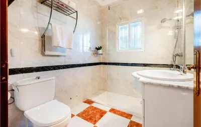 a white bathroom with a toilet and a sink at Lovely Home In Chiclana De La Fronter in Novo Sancti Petri