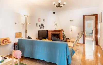 a living room with a blue couch and a fireplace at Lovely Home In Chiclana De La Fronter in Novo Sancti Petri