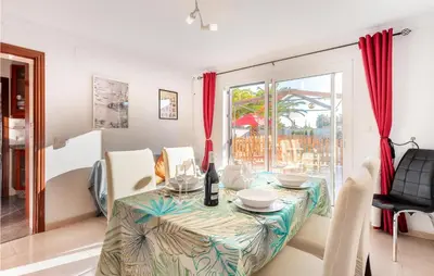 a dining room with a table and a window at Lovely Home In Chiclana De La Fronter in Novo Sancti Petri
