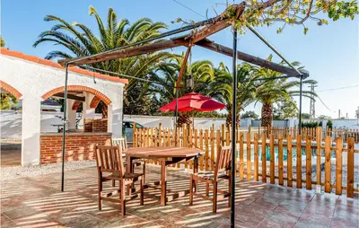 a table and chairs and an umbrella on a patio at Lovely Home In Chiclana De La Fronter in Novo Sancti Petri