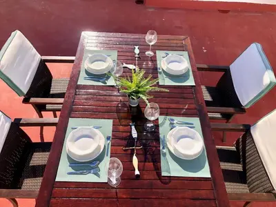 a wooden table with plates and wine glasses on it at GATU PREMIUM La Casa del Arco con wifi, aire acc, terraza ,