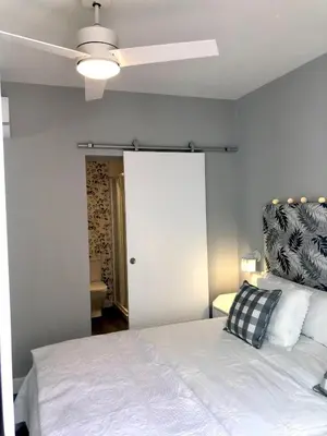 a bedroom with a white bed and a ceiling fan at GATU PREMIUM La Casa del Arco con wifi, aire acc, terraza ,