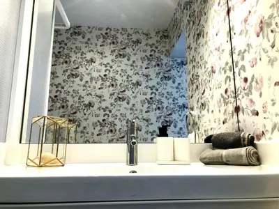 a bathroom with a sink with a floral wallpaper at GATU PREMIUM La Casa del Arco con wifi, aire acc, terraza ,