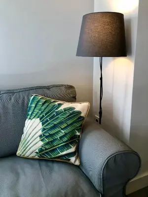 a pillow sitting on a couch next to a lamp at GATU PREMIUM La Casa del Arco con wifi, aire acc, terraza ,