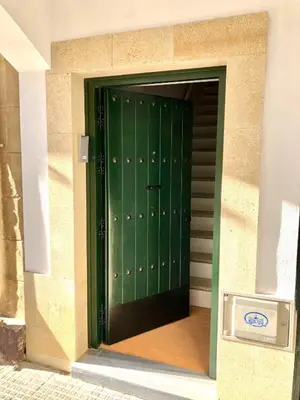 a green door on the side of a building at GATU PREMIUM La Casa del Arco con wifi, aire acc, terraza ,