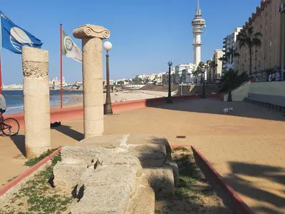 a view of a beach with a lighthouse in the background at Apartment Huerta del Obispo in Cádiz