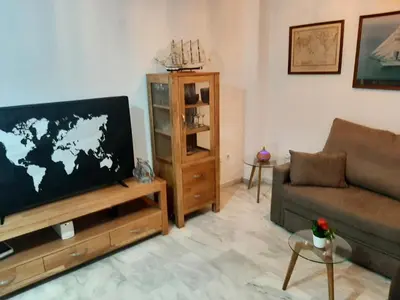 a living room with a couch and a flat screen tv at Apartment Huerta del Obispo in Cádiz