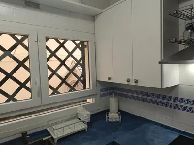 a kitchen with a window and a blue floor at Apartment Huerta del Obispo in Cádiz