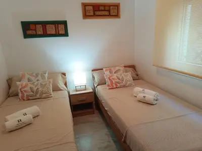 two beds in a room with a lamp on a table at Apartment Huerta del Obispo in Cádiz